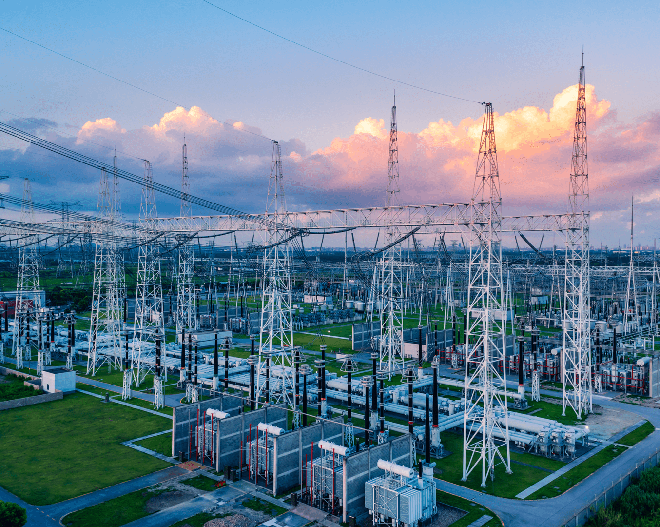 Electric substation with transmission towers at sunset.