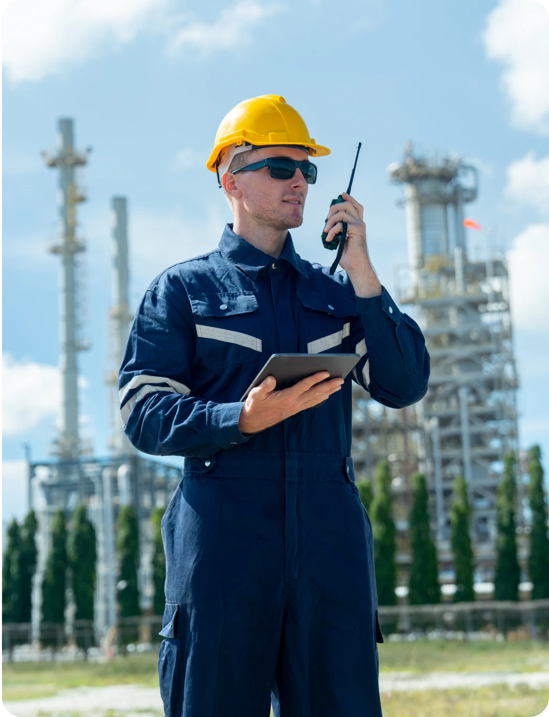 Engineer with tablet and radio at plant.