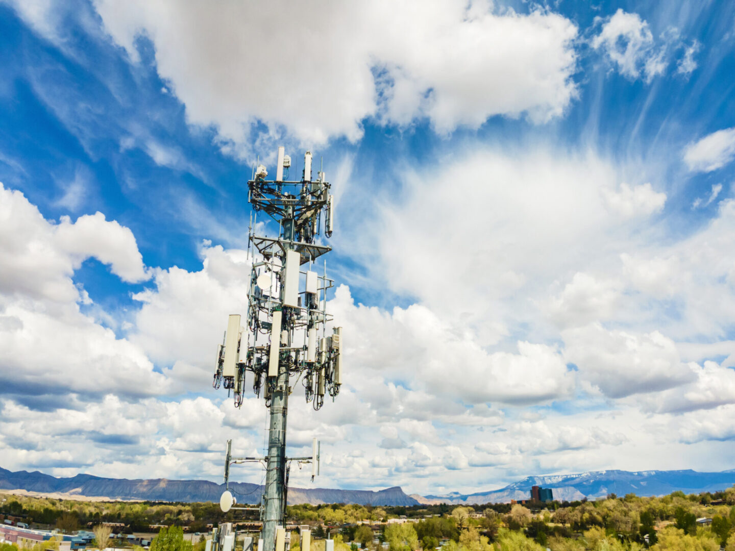 Cell tower with antennas under blue sky