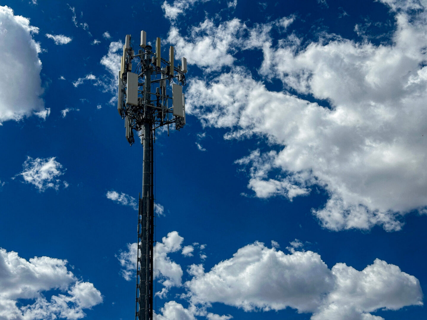 Cell tower against blue sky and clouds