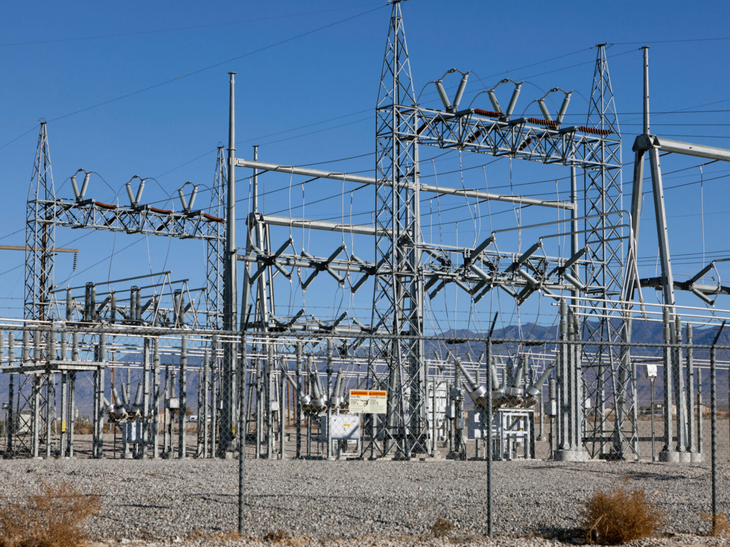 High-voltage electrical substation under clear blue sky